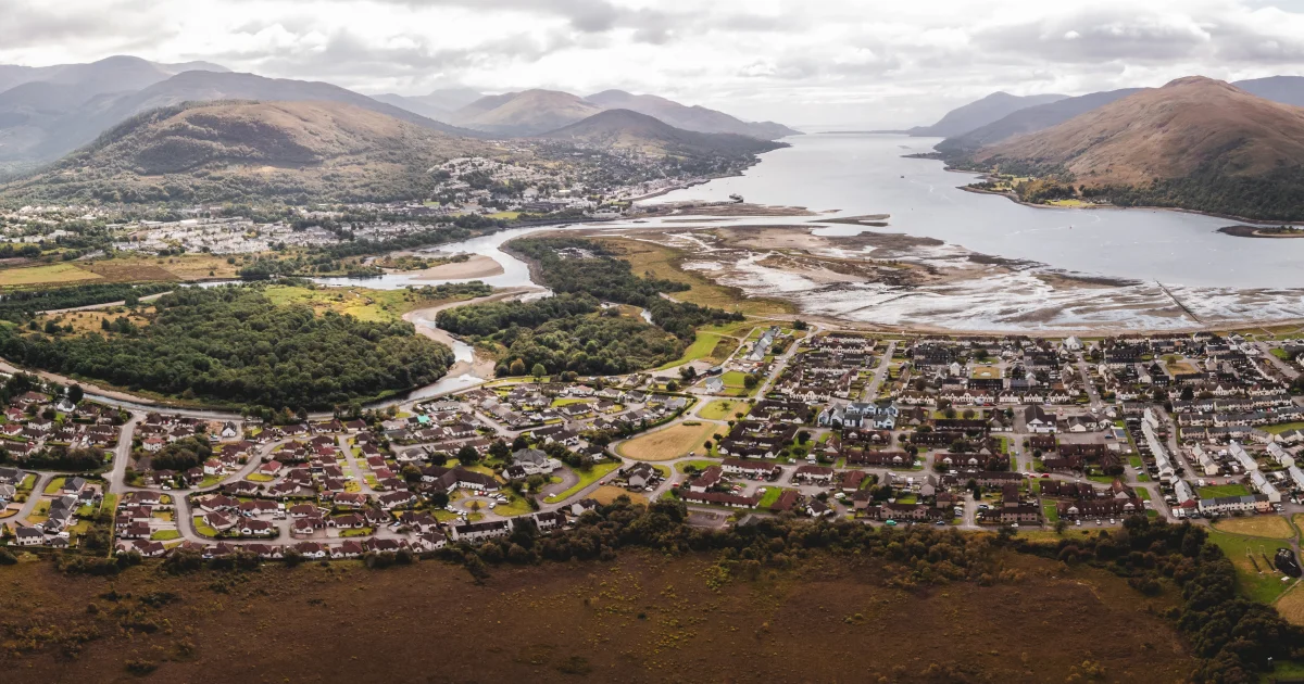 Aerial panorama of Fort William beside Loch Linnhe, with Ben Nevis and the Highland mountains behind
